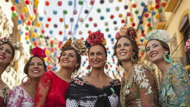 Mujeres vestidas de flamenca en la calle Larios.